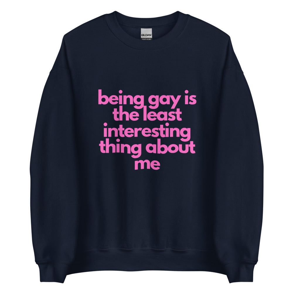 This is a pride apparel crewneck sweatshirt. It is navy and has "being gay is the least interesting thing about me" written across the front in pink letters.