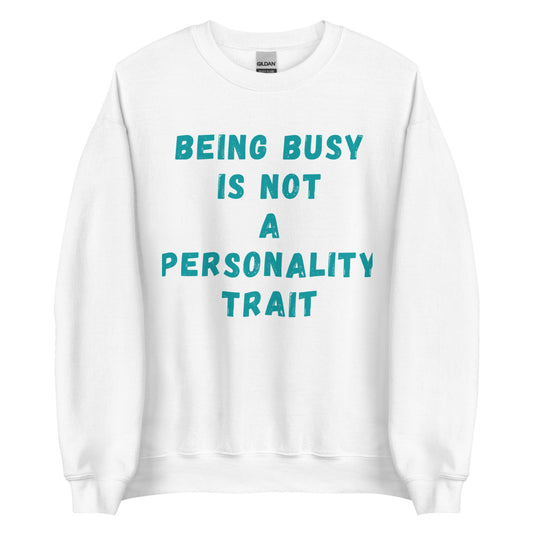 This is a funny crewneck sweatshirt. It is white and has "Being busy is not a personality trait" written across the front in an aqua color font.
