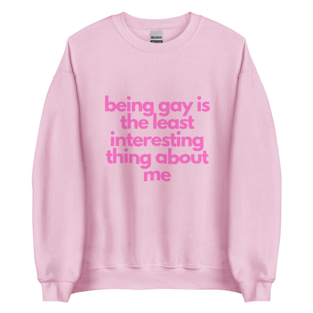 This is a pride apparel crewneck sweatshirt. It is light pink and has "being gay is the least interesting thing about me" written across the front in pink letters.