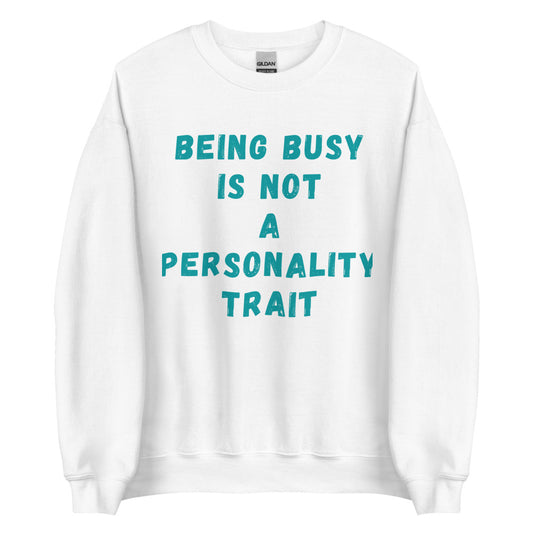 This is a funny crewneck sweatshirt. It is white and has "Being busy is not a personality trait" written across the front in an aqua color font. 